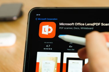 Microsoft office lens logo shown by apple pencil on the iPad Pro tablet screen. Man using application on the tablet. December 2020, San Francisco, USA.