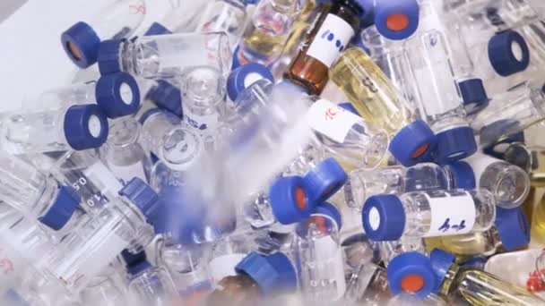 Caindo para baixo frascos de vidro HPLC com tampas azuis após a análise. Testes errados da vacina contra o coronavírus. — Vídeo de Stock