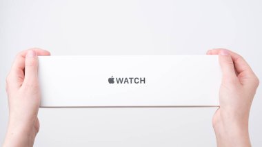 Apple watch box in woman hands on the grey background with copy space, December 2020, San Francisco, USA