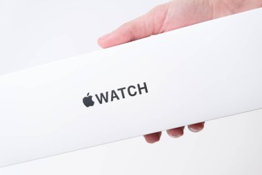 Apple watch box in woman hand on the grey background with copy space, December 2020, San Francisco, USA