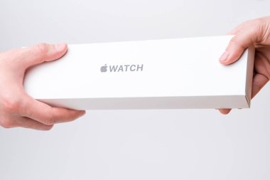 Man and woman hand holding a box with Apple watch on the grey background, December 2020, San Francisco, USA