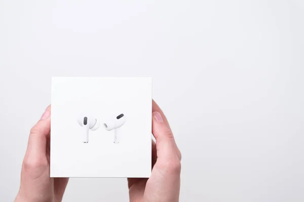AirPods box in woman hands on the grey background with copy space, December 2020, San Francisco, USA — Foto de Stock