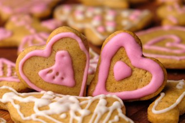 Sevgililer Günü için ahşap masada diğer ev yapımı kurabiyelerle birlikte iki tane zencefilli kek..