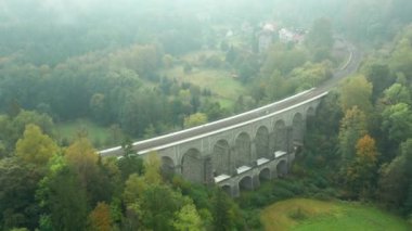 Kemer köprüsünün panoramik görüntüsü ya da ağaçların arasındaki tarihi su kemeri. 