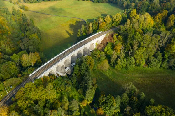 An aqueduct or arched bridge in the terrain with high trees and beautiful landscape at sunlight. — Stock Photo, Image