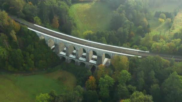 Aquädukt oder Bogenbrücke im Gelände mit hohen Bäumen und schöner Landschaft bei Sonneneinstrahlung. — Stockvideo