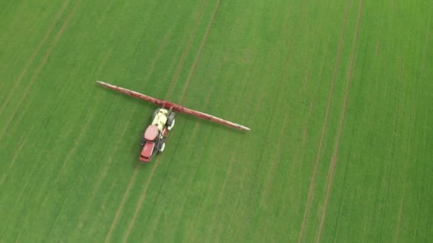 Съемка с воздуха тракторного удобрения химическими веществами на пшеничном поле зеленого сельского хозяйства. — стоковое видео