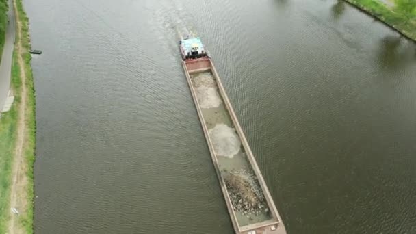 Vista aérea de una gran barcaza de carga que se mueve a lo largo del río. Buque de carga o remolcador que transporta arena o materia prima. — Vídeos de Stock