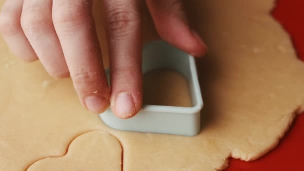 Hacer galletas en forma de corazón para el Día de San Valentín con molde de plástico en la alfombra de silicona roja para hornear. — Vídeos de Stock