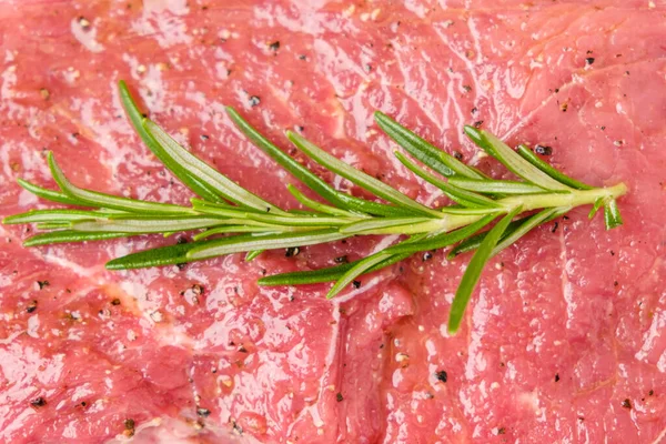 Rohes Rindersteak mit Rosmarinzweig und auf weißem Hintergrund isolierten Arten. — Stockfoto