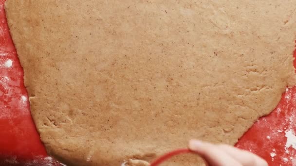 Faire des biscuits en forme de cœur pour la Saint-Valentin en utilisant un moule en plastique rouge sur le tapis de cuisson en silicone rouge. — Video