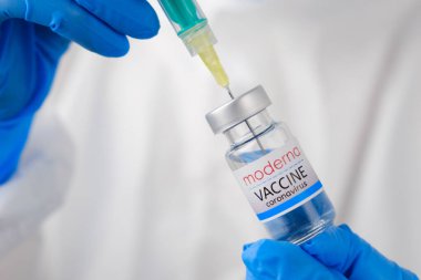 Moderna koronavirüs aşısı ve şişedeki şırınga ya da şırıngayı doktorun ellerine vermek için. Covid-19, SARS-Cov-2 önleme, Ocak 2021, San Francisco, ABD