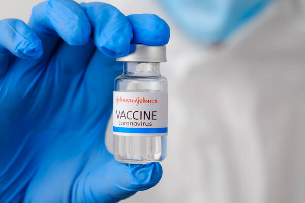 Johnson and johnson coronavirus vaccine in doctors or nurses hands in blue rubber gloves. Prevention of sars-cov-2 or Covid-19, January 2021, San Francisco, USA.