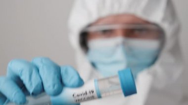 Koronavirüsün doktor elinde önlenmesi için aşı koruyucu maske ve koruyucu PPE giysi ve lastik eldivenler..