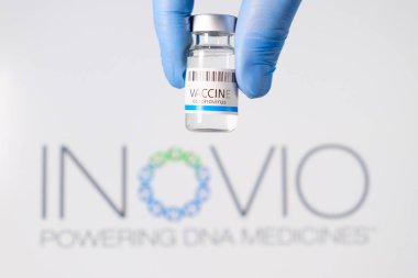 Doktorların şişesindeki Inovo aşısı logonun arka planında lastik eldivenler verdi, Ocak 2021, San Francisco, ABD