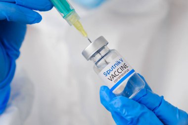 Sputnik V Coronavirus aşısı ve şişedeki şırınga ya da şırıngayı doktorun ellerine vermek için. Covid-19, SARS-Cov-2 önleme, Ocak 2021, San Francisco, ABD.