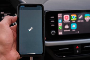 Apple Car oyununun navigasyon veya haritalarının uygulandığı gösterge panelinin arka planındaki akıllı telefon ekranında uygulamayı görüyorsunuz. Ocak 2021, Prag, Çek Cumhuriyeti