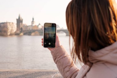 Prag 'dan blogcu ya da etkili bir kayıt videosu. Vlogger cep telefonundan video bloğu çekiyor. Kız akıllı telefonuyla fotoğraf çekiyor. Seyahat içeriği