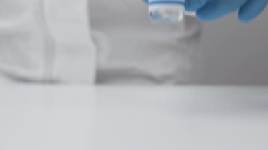 Coronavirus aşısı ve enjeksiyon için şırınga kauçuk eldiven ve koruyucu giysi, Mart 2021, San Francisco, ABD