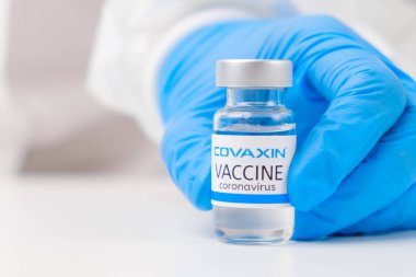 SARS-Cov-2, Coronavirus ya da Covid-19 'a karşı kovaxin aşısı plastik eldivenli tıp çalışanı tarafından masaya kondu.. 