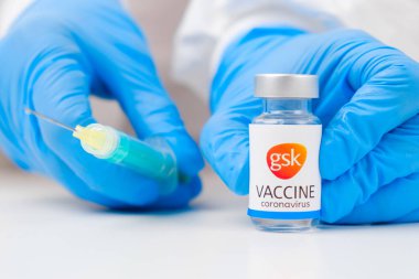 Koronavirüse karşı GSK aşısı ve sağlık çalışanlarına enjeksiyon için şırınga kauçuk eldiven ve koruyucu giysi, Mart 2021, San Francisco, ABD