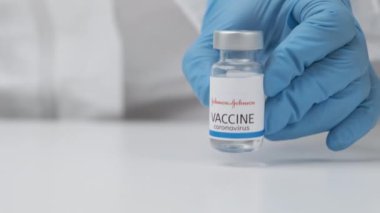 Johnson ve Johnson 'ın Coronavirus aşısı sağlık çalışanlarının ellerinde lastik eldiven ve koruyucu giysi, Mart 2021, San Francisco, ABD