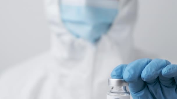 Ковишфильдская вакцина против коронавируса в руке медицинского работника в резиновых перчатках и защитном костюме, март 2021 года, Сан-Франциско, США — стоковое видео