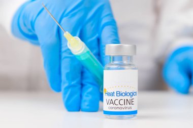 Coronavirüs 'e karşı ısı aşısı ve sağlık çalışanlarına enjeksiyon için şırınga kauçuk eldiven ve koruyucu giysi, Mart 2021, San Francisco, ABD