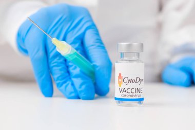 Koronavirüse karşı CytoDyn aşısı ve sağlık çalışanlarına enjeksiyon için şırınga kauçuk eldiven ve koruyucu giysi, Mart 2021, San Francisco, ABD