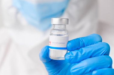 Biyolojik ilaç şişesi ya da enjeksiyon için ilaç şişesi ya da plastik eldivenli bilim adamlarına verilen ilaçlar. Mart 2021, San Francisco, ABD