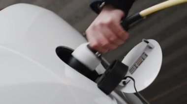 Elektrikli araca şarj için güç kaynağını kesen adam. Alt görünüm. 
