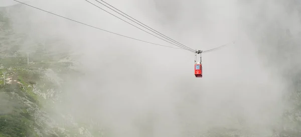 Rote Standseilbahn oder rote Hängebahn auf den Lomnitzgipfel bei Nebel oder Wolken, September 2020, Hohe Tatra, Slowakei — Stockfoto