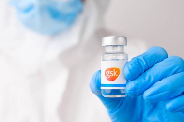 GSK ilaç şişesi ya da şişesi sağlık çalışanı ya da bilim adamı tarafından plastik eldivenlerle gösterildi, Nisan 2021, San Francisco, ABD 