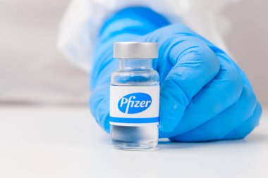 Pfizer şişesi ya da şişesi sağlık çalışanı ya da bilim adamı tarafından plastik eldivenlerle gösterilmiş, Nisan 2021, San Francisco, ABD 