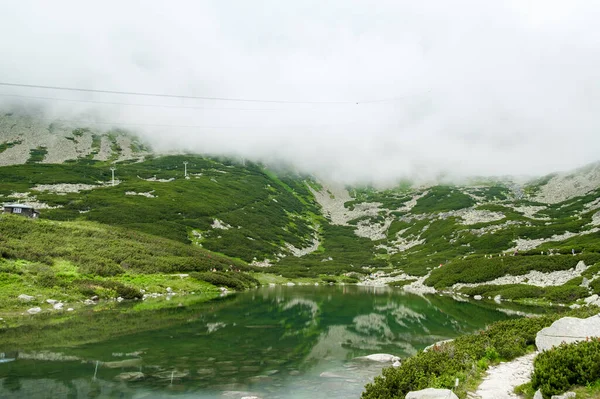 Górski strumień z widokiem na skaliste góry i jezioro z przezroczystą wodą — Zdjęcie stockowe
