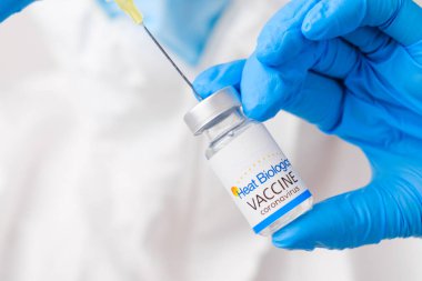 Isı Biyolojisi aşısı şırıngada sağlık çalışanı veya doktor tarafından koruyucu eldivenler ve PPE süitinde, Nisan 2021, San Francisco, ABD