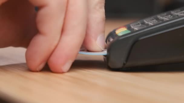 Закрыть человек рука вставляет кредитную карту в pos терминал для безналичной оплаты. — стоковое видео
