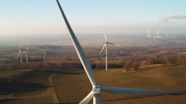 Cerrar una gran turbina eólica giratoria en el fondo del parque eólico al atardecer. — Vídeos de Stock