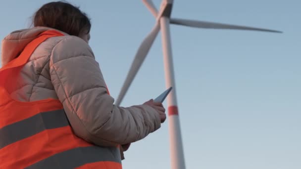 A wind turbine inspector standing with tablet and controls the system. Generation of electricity. — Stock Video