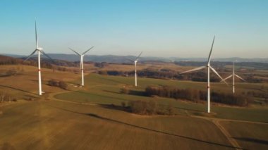 Gün batımında rüzgar türbinleri çiftliğinin havadan görüntüsü. Yeşil enerji üretimi ve elektrik üretimi. 
