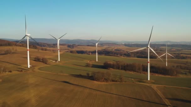 Gün batımında rüzgar türbinleri çiftliğinin havadan görüntüsü. Yeşil enerji üretimi ve elektrik üretimi. — Stok video