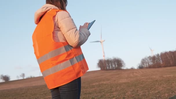 Rüzgar türbini teknisyeni akşamları yel değirmenlerini kontrol ediyor. Yeşil elektrik üretimi — Stok video