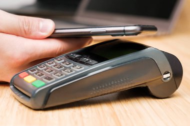 Adam akıllı telefonlu kablosuz bağlantı terminali ödemesi kullanıyor.