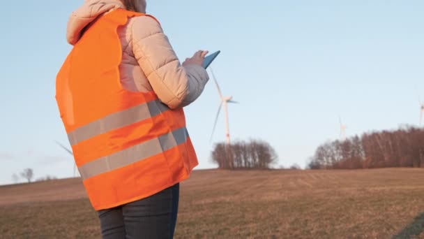 Vindturbintekniker styr driften av väderkvarnar på kvällen. Grön elproduktion — Stockvideo