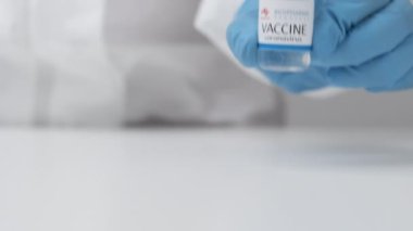 Koronavirüse karşı biyofarma aşısı ve sağlık çalışanlarına enjeksiyon için şırınga kauçuk eldiven ve koruyucu giysi, Nisan 2021, San Francisco, ABD