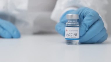 Koronavirüse karşı biyofarma aşısı ve sağlık çalışanlarına enjeksiyon için şırınga kauçuk eldiven ve koruyucu giysi, Nisan 2021, San Francisco, ABD