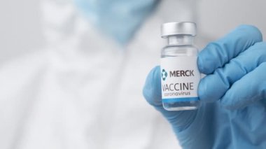 Coronavirus 'a karşı merck aşısı ve sağlık çalışanlarına enjeksiyon için şırınga plastik eldiven ve koruyucu giysi, Nisan 2021, San Francisco, ABD