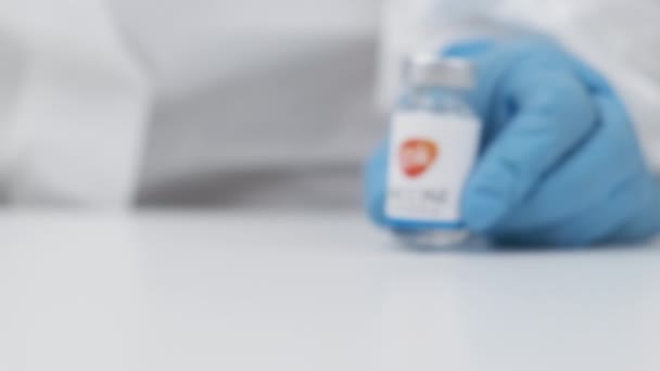 Koronavirüse karşı GSK aşısı ve sağlık çalışanlarına enjeksiyon için şırınga kauçuk eldiven ve koruyucu giysi, Nisan 2021, San Francisco, ABD — Stok video