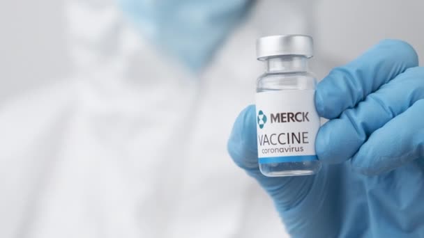 Merck vakcína proti koronaviru a injekční stříkačce ve zdravotnické ruce v gumových rukavicích a ochranném obleku, duben 2021, San Francisco, USA — Stock video