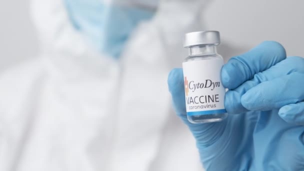 CytoDyn vacina contra coronavírus e seringa para injeção em mão de trabalhador de saúde em luvas de borracha e terno de proteção, abril de 2021, San Francisco, EUA — Vídeo de Stock